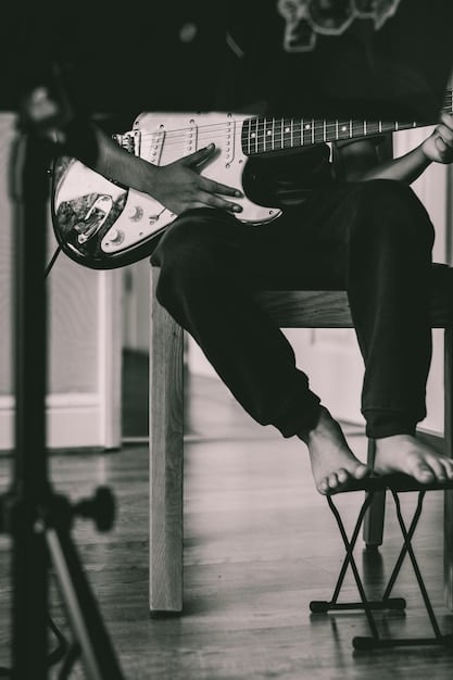 A close-up shot of Joe Duplantier's hands and guitar during a recording session, with focus on the intricate details of his playing and the guitar itself. The image has a warm, studio-like atmosphere.