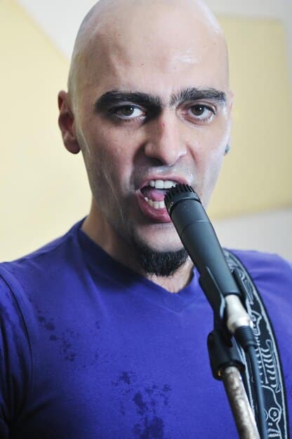 A close up studio shot featuring Killswitch Engage band members during a recording session. Focus on Adam Dutkiewicz engineering with a focused expression. This photo should give a view of behind the scenes studio creativity, highlighting the atmosphere and effort involved in creating the music.