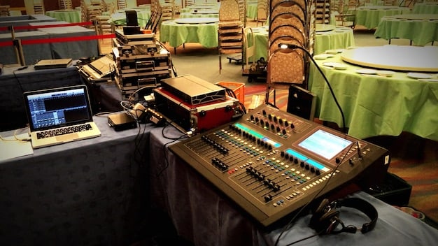 A cluttered studio setup featuring a vintage sampler, a rack of effects processors, and a mixing console, all bathed in dim, ambient light. The scene captures the experimental and hands-on approach to sound design typical of industrial metal production.