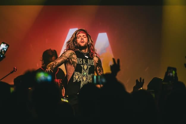 A lead singer of a heavy metal band interacts with the crowd during a concert. The singer is making eye contact and gesturing to the audience.