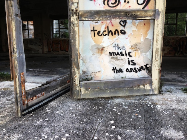 A clear sign at the entrance of a heavy metal concert venue listing prohibited items, such as weapons, outside food and beverages, and illegal substances, accompanied by a security guard checking attendees' bags.