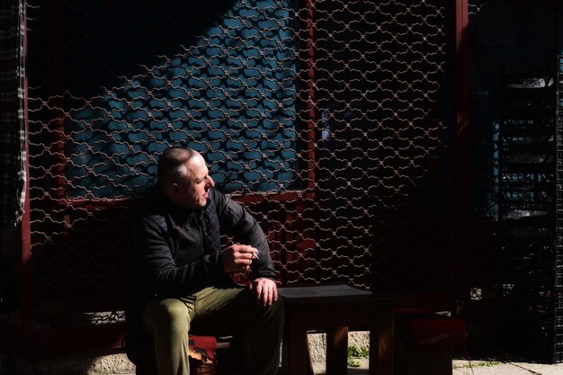 A dimly lit backstage scene, with the rock legend looking dejected and exhausted, sitting alone on a worn-out couch, holding their head in their hands, symbolizing the weight of their financial burdens.