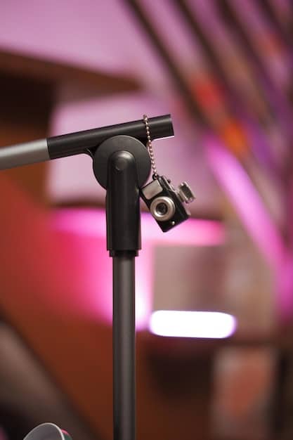 A close up of a microphone in a studio during a recording session. The background is blurred but suggests a professional environment.