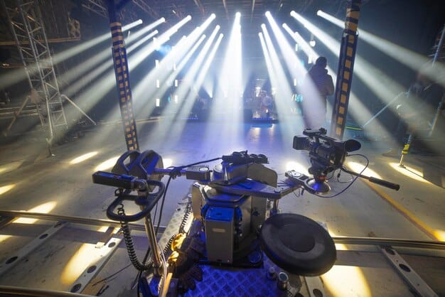 A band performing on a national TV show, with bright stage lighting and professional camera angles capturing their energy and performance. The backdrop is visually appealing, and the audience is engaged and enthusiastic.