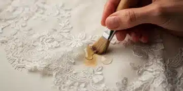 Hand gently cleaning delicate vintage lace fabric with brush