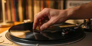 Hand placing a vinyl record on a turntable, emphasizing the tactile experience of analog music playback.