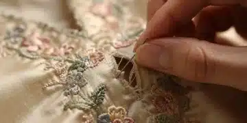 Expert hands mending a delicate vintage silk blouse to reduce repair costs